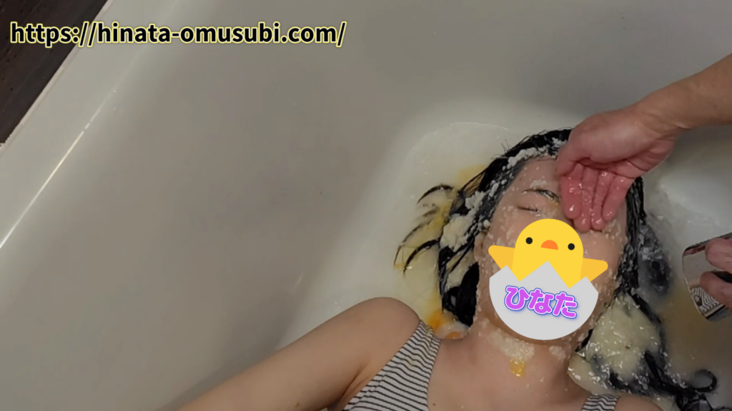 メッシープレイで汚れた顔をシャワーで洗う女性