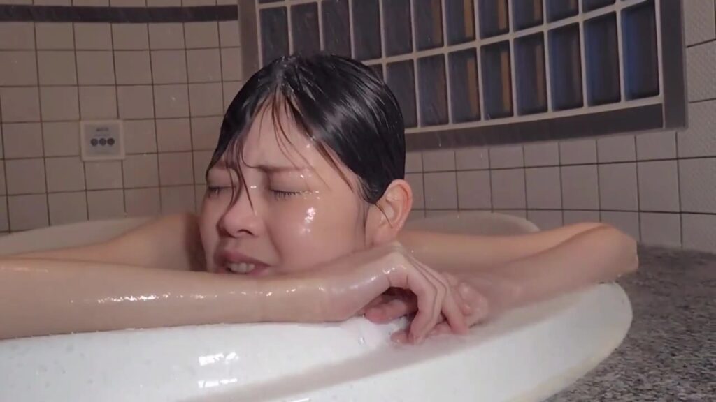 浴槽のふちに腕をのせて、シャワーをこらえるゲストモデルDさん