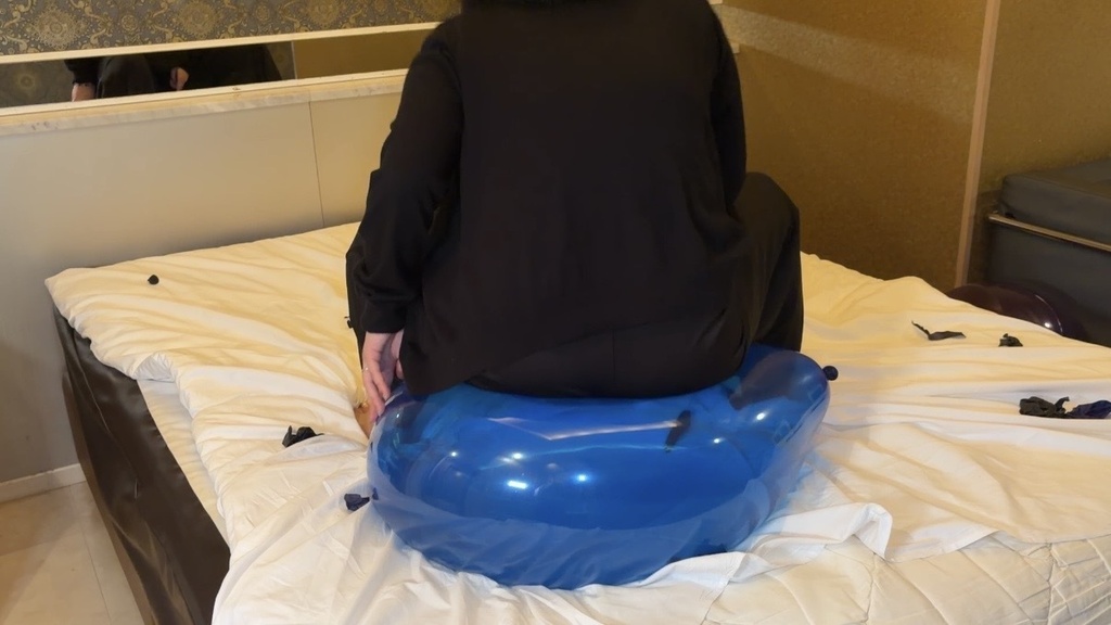 女の子のお尻に潰されている巨大風船