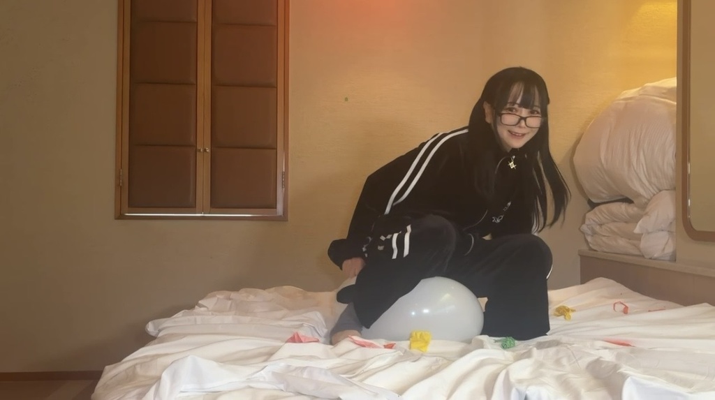 望月みうなさんが風船をお尻で割ろうとしている