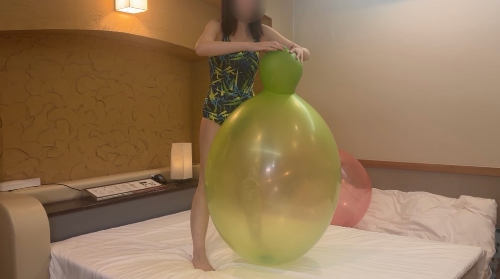 水着女子とボウリングのピンのような形の緑色の巨大風船