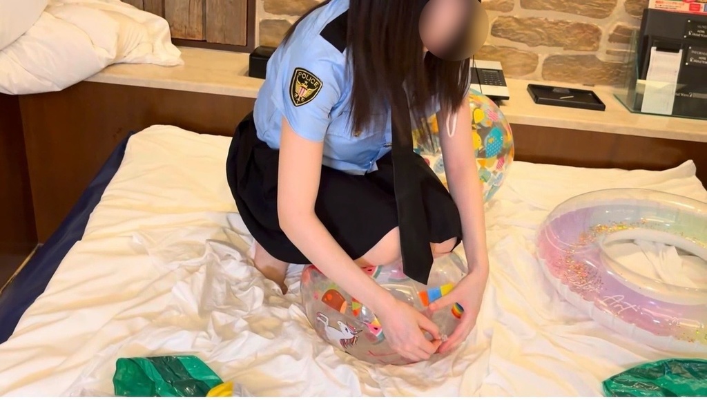 ビーチボールの空気を膝を使って抜こうとしてる女の子