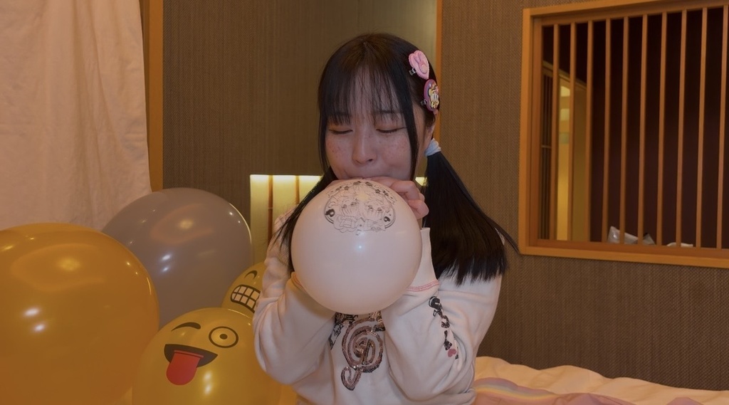 プリキュア風船を女の子が膨らましている