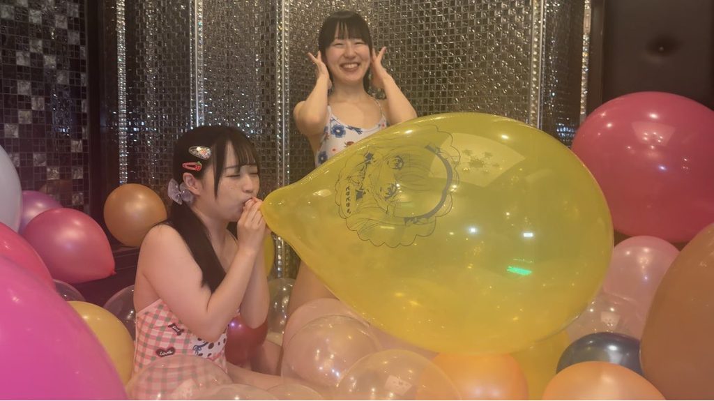 巨大風船を膨らませる水着姿の女の子