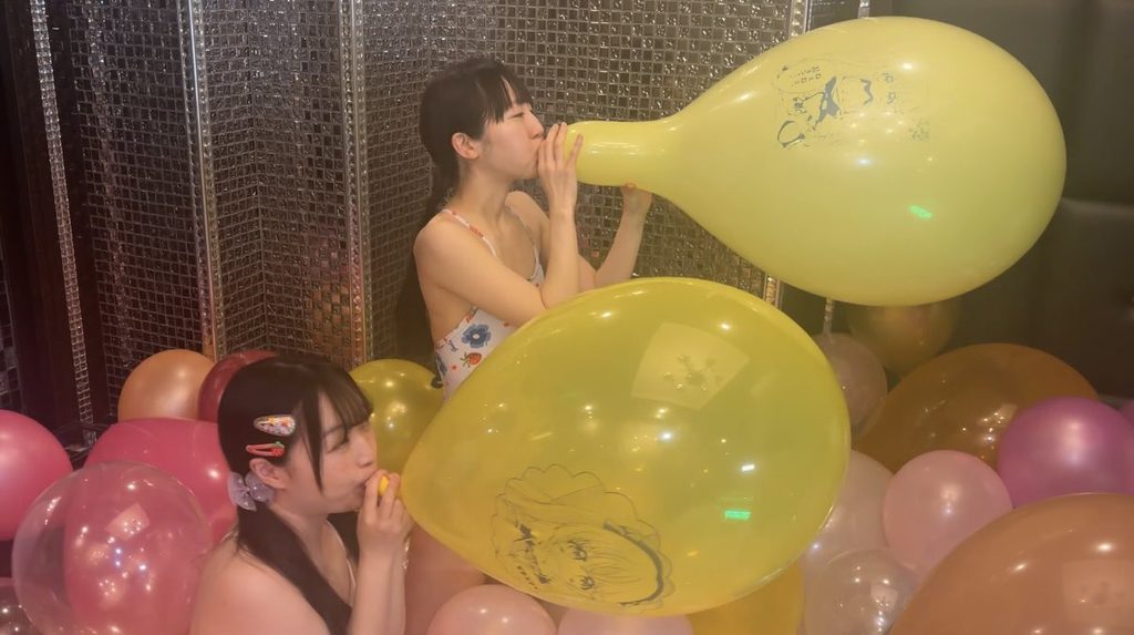 巨大風船を膨らませる女の子2人