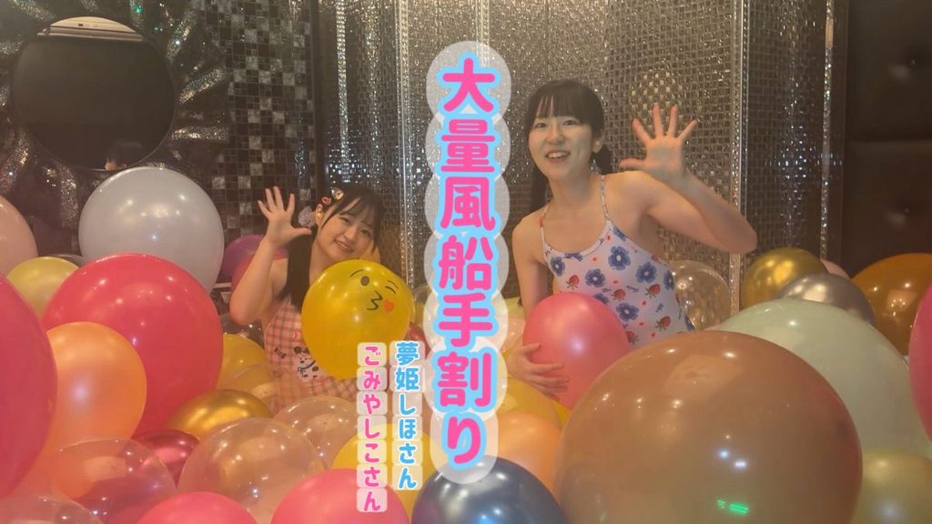 大量の風船の中に埋もれる水着女子2人
